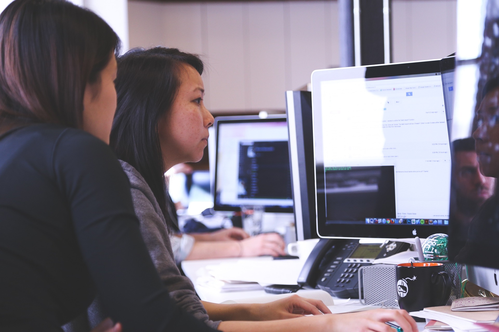 Two workers sitting at a desk collaborating on a project